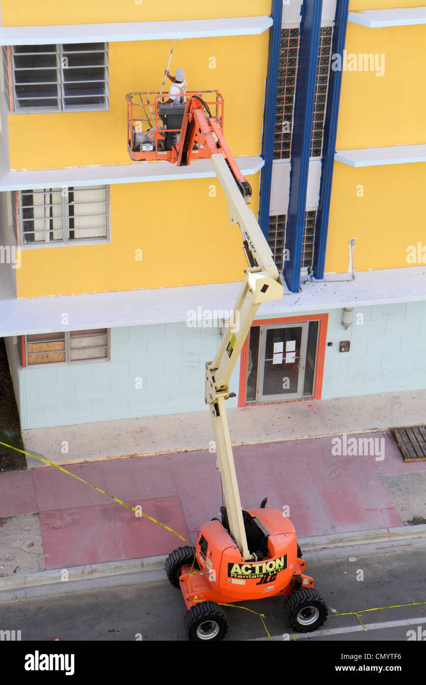 Miami Beach Florida,Ocean Drive,JLG articulating boom lift,Hispanic man men male adult adults,painter,building,painting,working,work,employee worker w Stock Photo