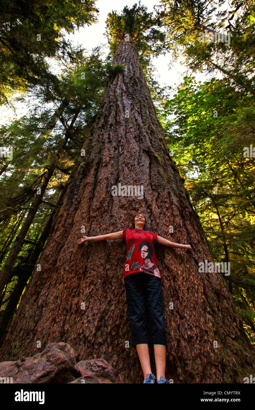 women posing uder 800 year old giant redwood Trees in Cathedral Grove National Park on Vancouver Island, Canada, North America Stock Photo