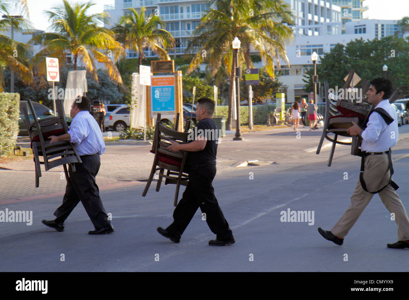 Miami Beach Florida,Collins Avenue,man men male adult adults,chairs,carrying,working,work,servers employee employees worker workers job jobs staff,hot Stock Photo