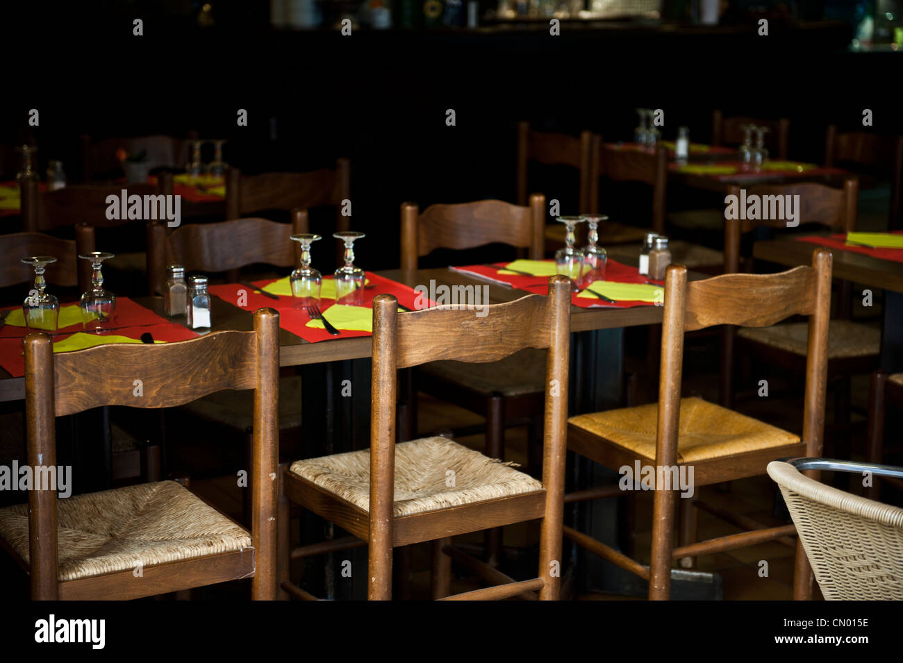 Dark dining restaurant with red and yellow table cloths. Stock Photo