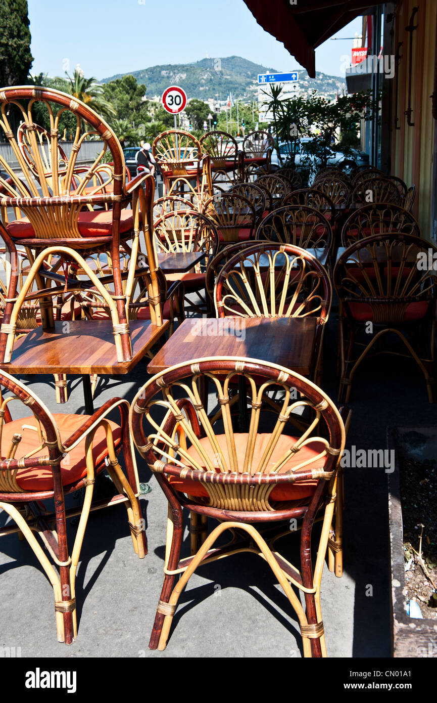Strawlike wooden chairs stacked on top of tables. Stock Photo