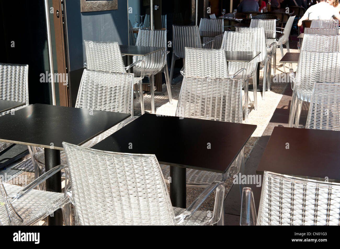 White, woven plastic chairs outside of a restaurant. Stock Photo