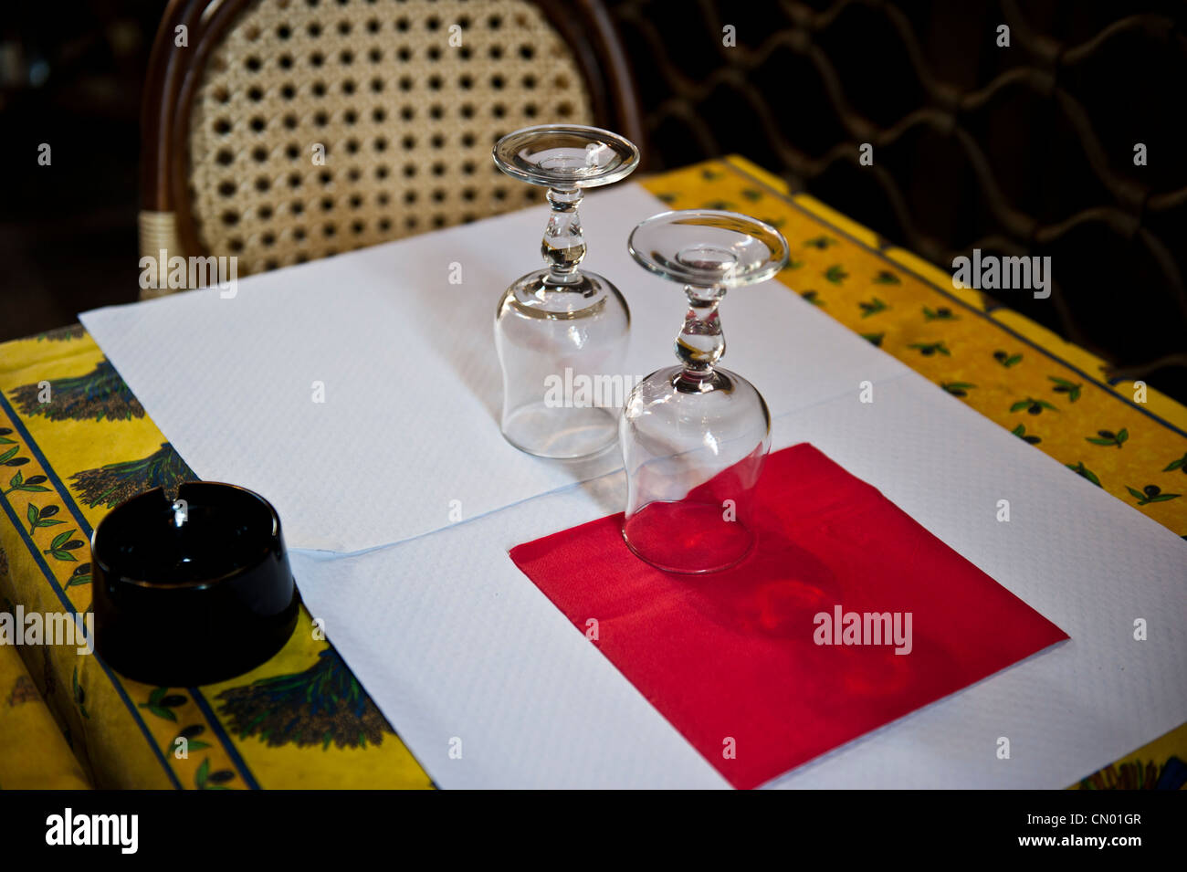 Table setting for two for a romantic dinner. Wine glasses are upside-down. Stock Photo