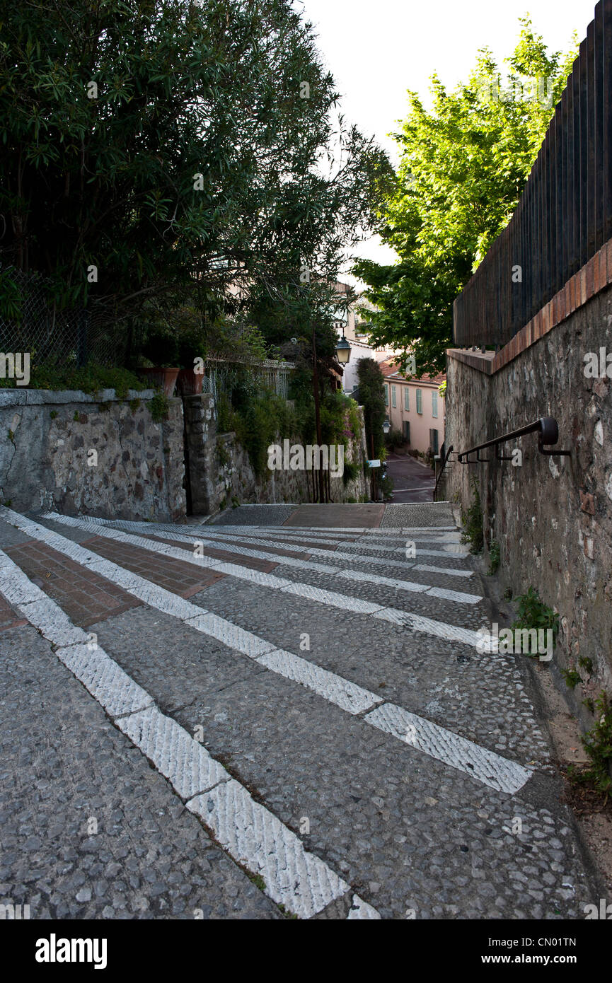 A long shot of a downhill alley in a suburban neighborhood of Cannes, France. Stock Photo
