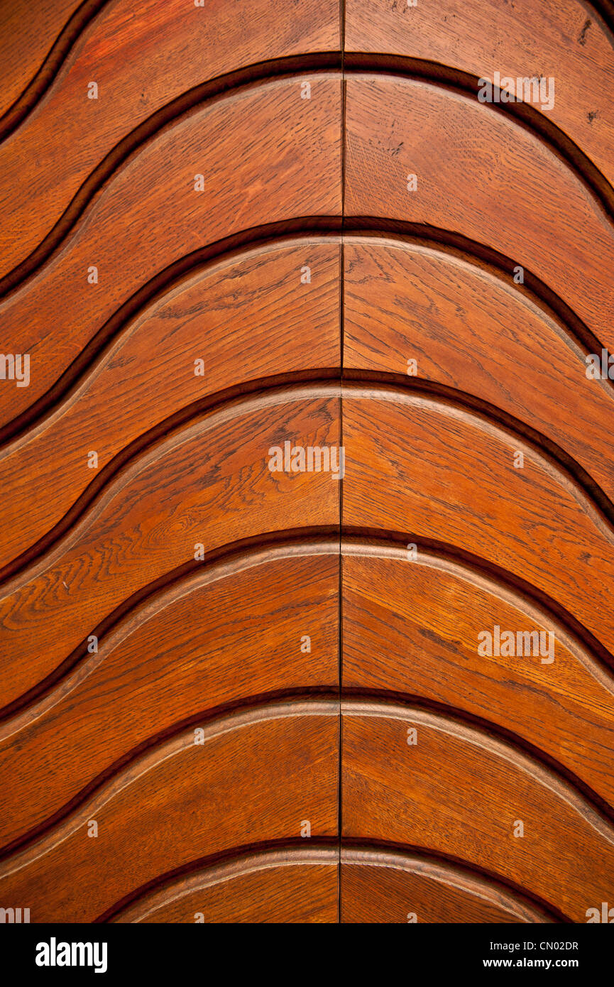 A bright color shot of a wooden door with grooved arching patterns ...