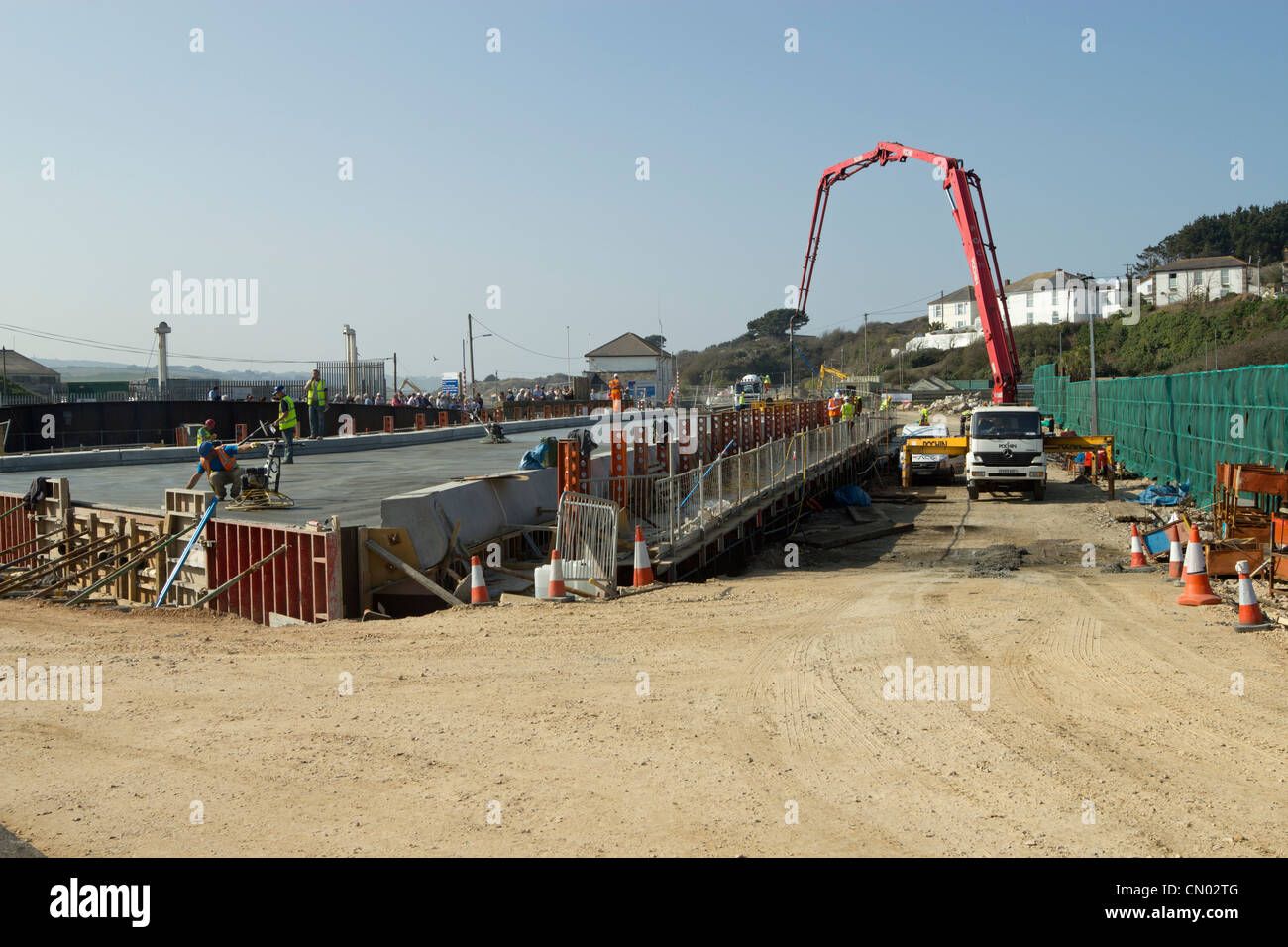 Smoothing the concrete during the concrete pour for the deck of the new bridge over Copperhouse Pool in Hayle, Cornwall UK. Stock Photo