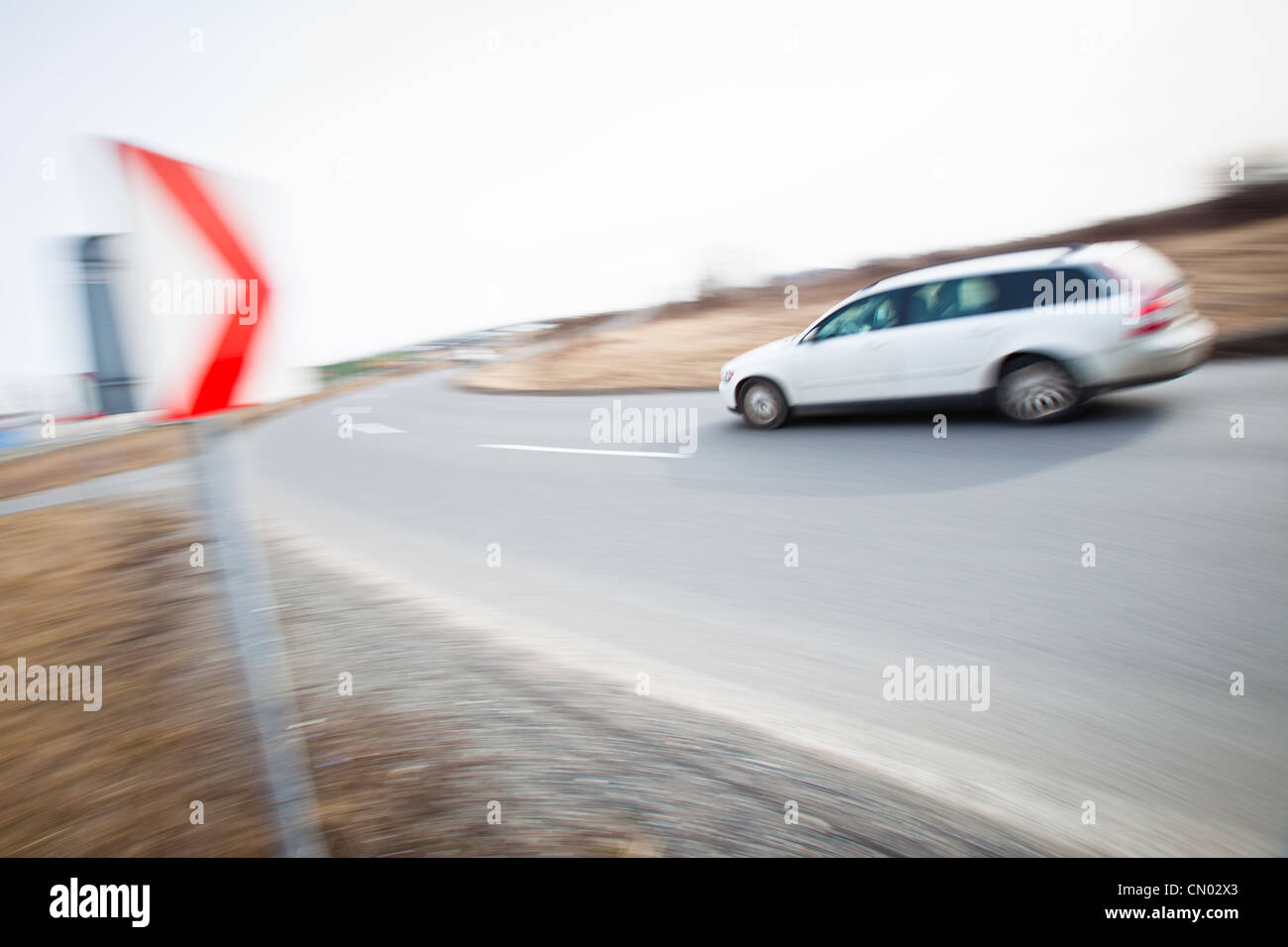 Traffic concept: car driving fast through a sharp turn (motion blur is ...