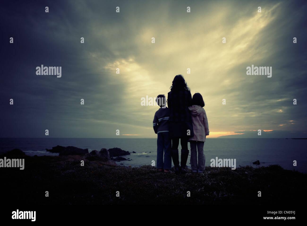 Mother son and daughter, ocean sunset, New Zealand. Stock Photo