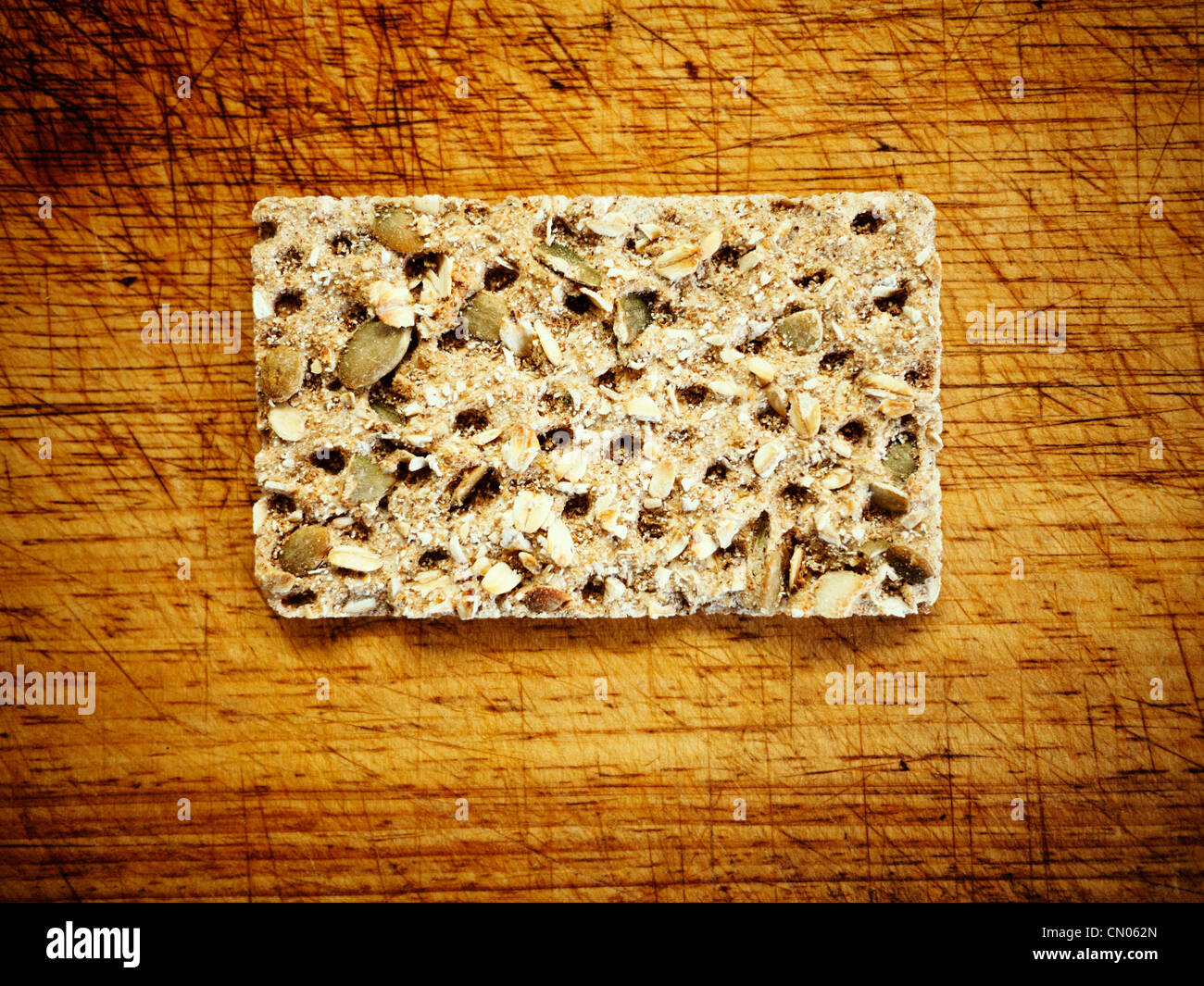 Savoury cracker biscuit with seeds on bread board. Stock Photo