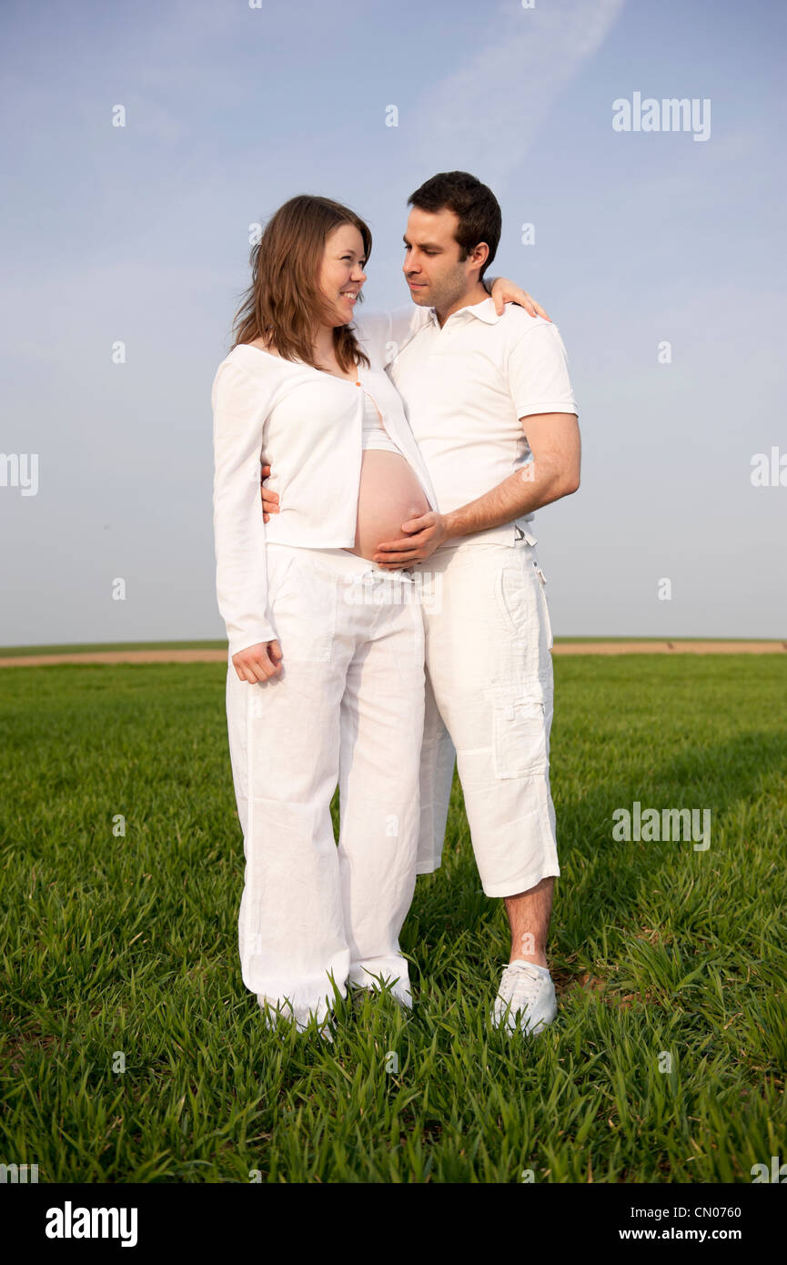 young couple in white outdoors in the fields, pregnant woman Stock ...