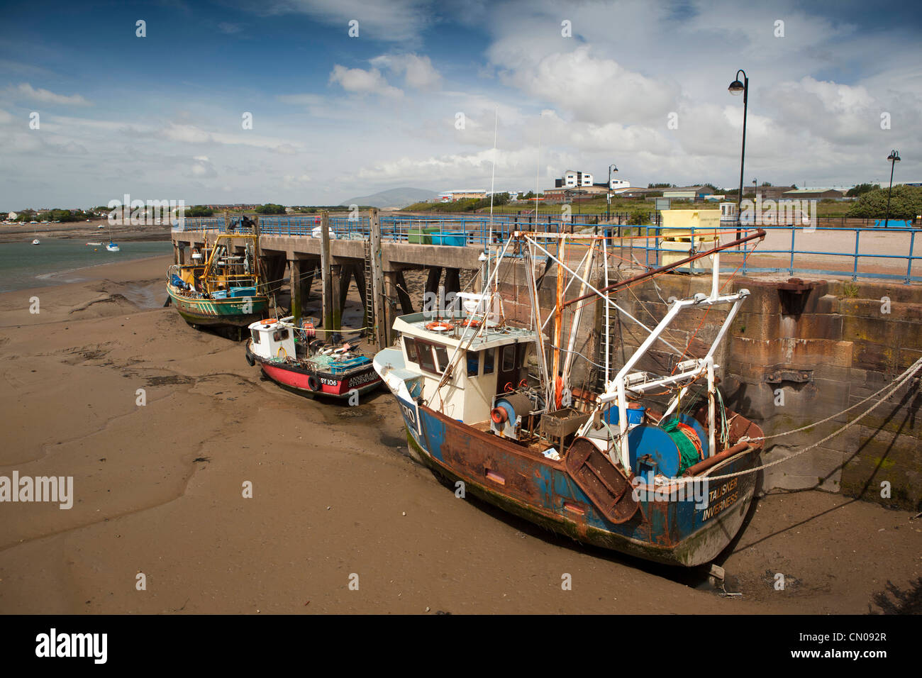 UK, Cumbria, Barrow in Furness, fishing boats moored at working quay at low tide Stock Photo