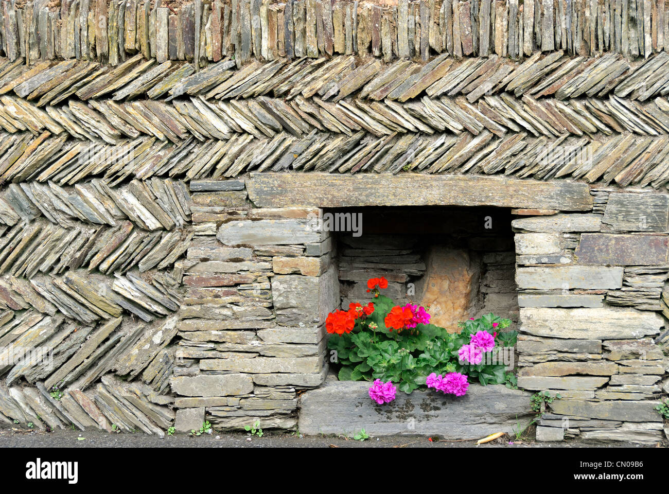 wall with diagonal stones and flowers Stock Photo - Alamy