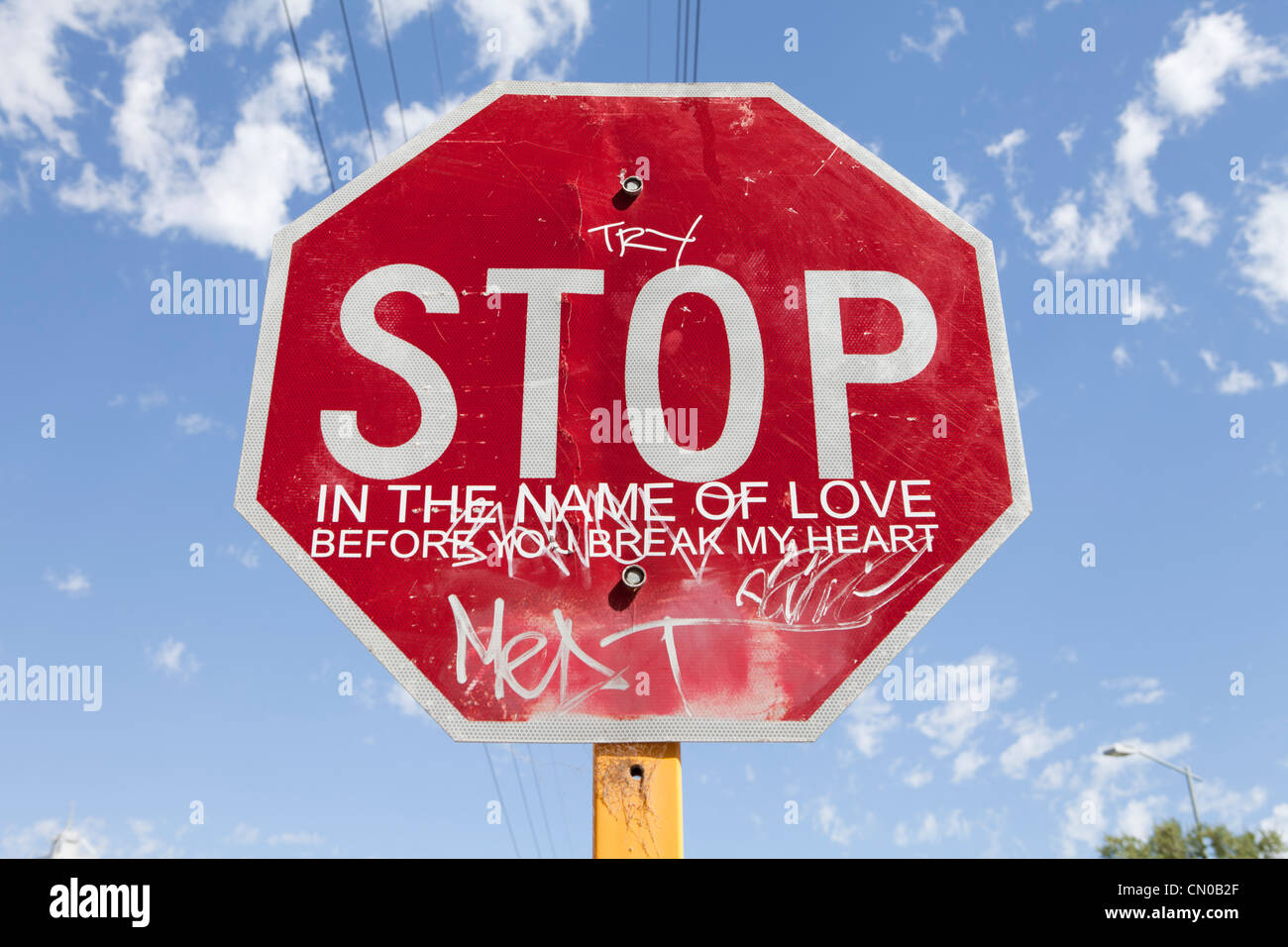 Stop sign that has been vandalised adding a song lryric by the supreams Stock Photo