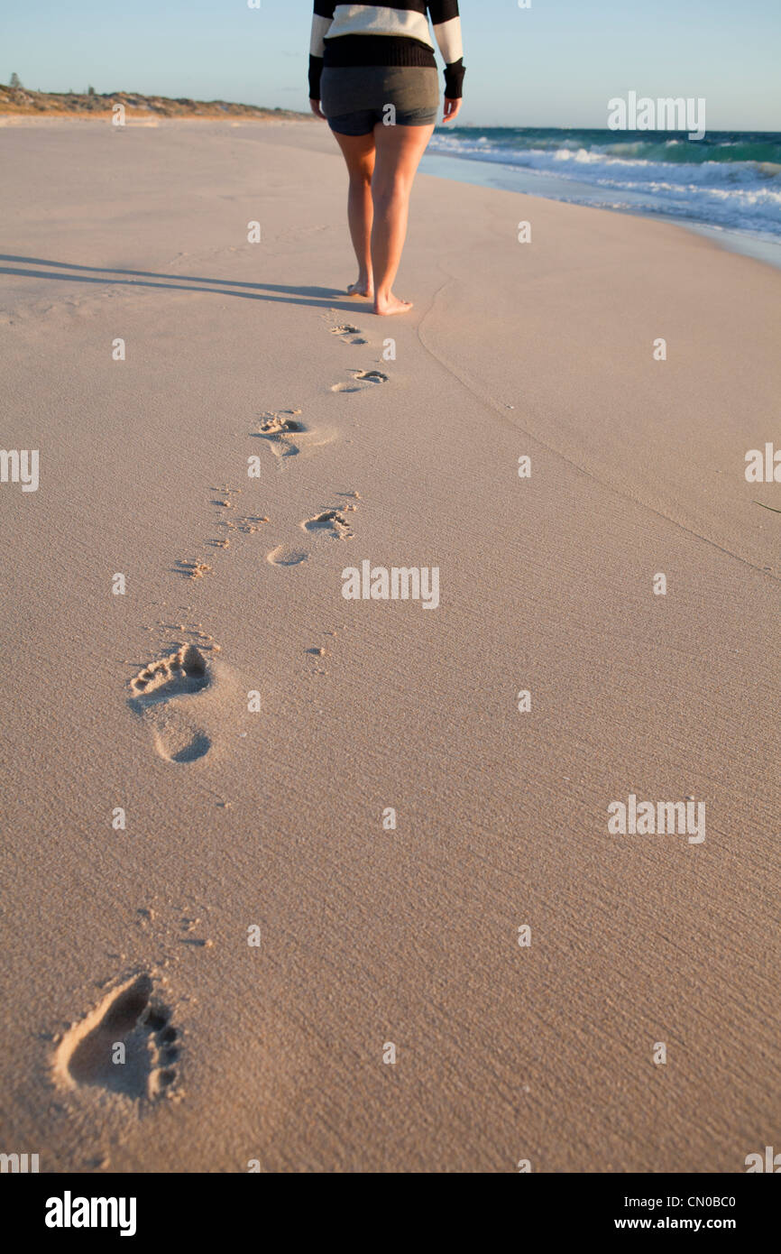 A young woman taking a beach walk along the beach Stock Photo Alamy