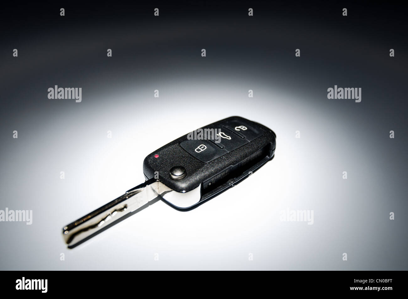 Modern black open car key on dark background in spot of light, wide ...