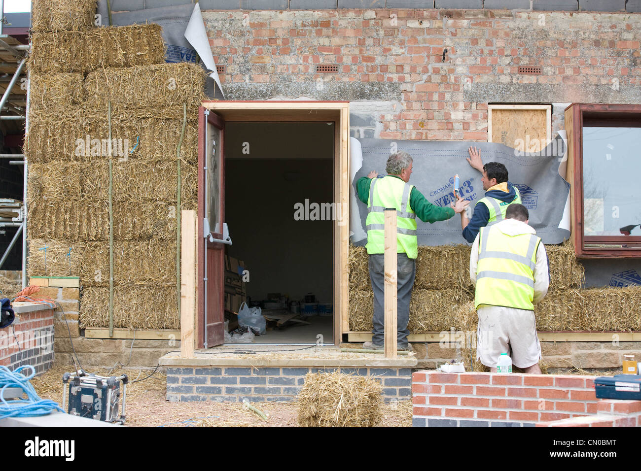 Builders using straw for insulation on a new Ecofriendly building