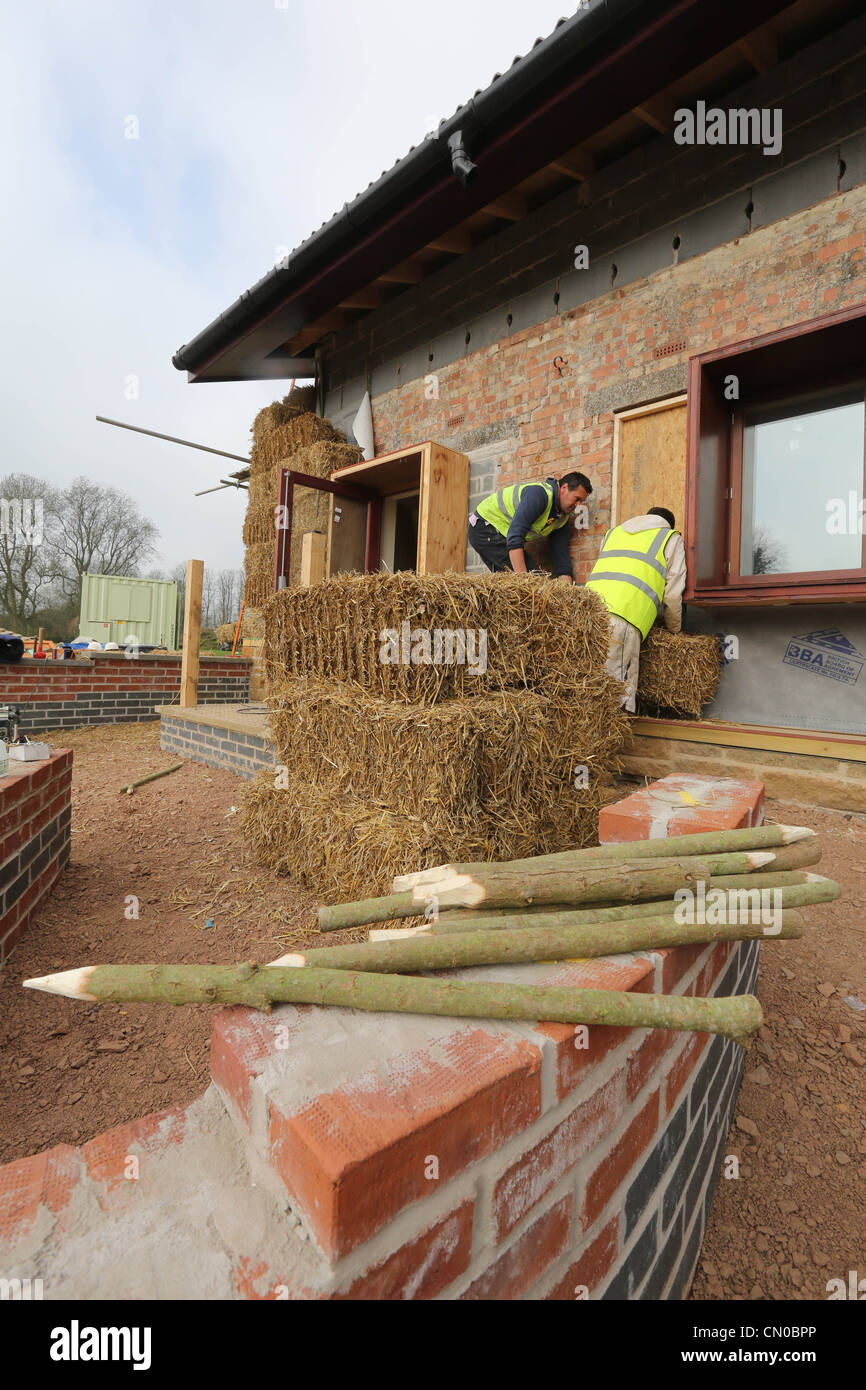 Builders using straw for insulation on a new Ecofriendly building