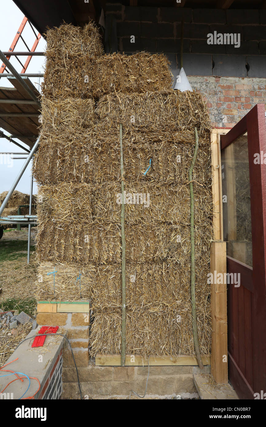 Builders using straw for insulation on a new Ecofriendly building