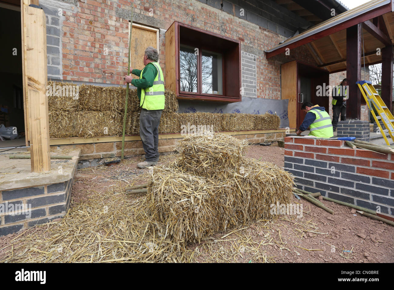 Builders using straw for insulation on a new Ecofriendly building
