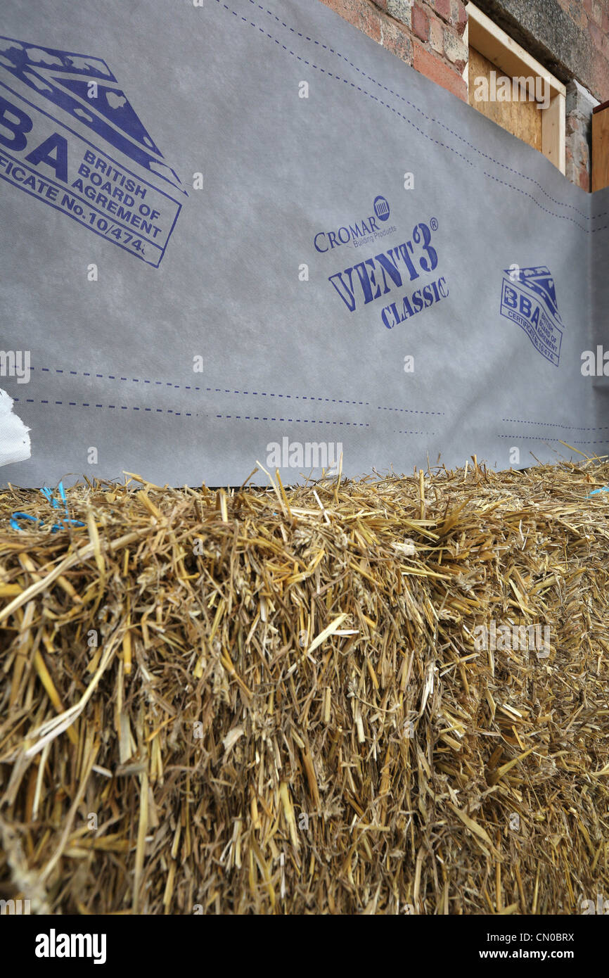 Builders using straw for insulation on a new Ecofriendly building