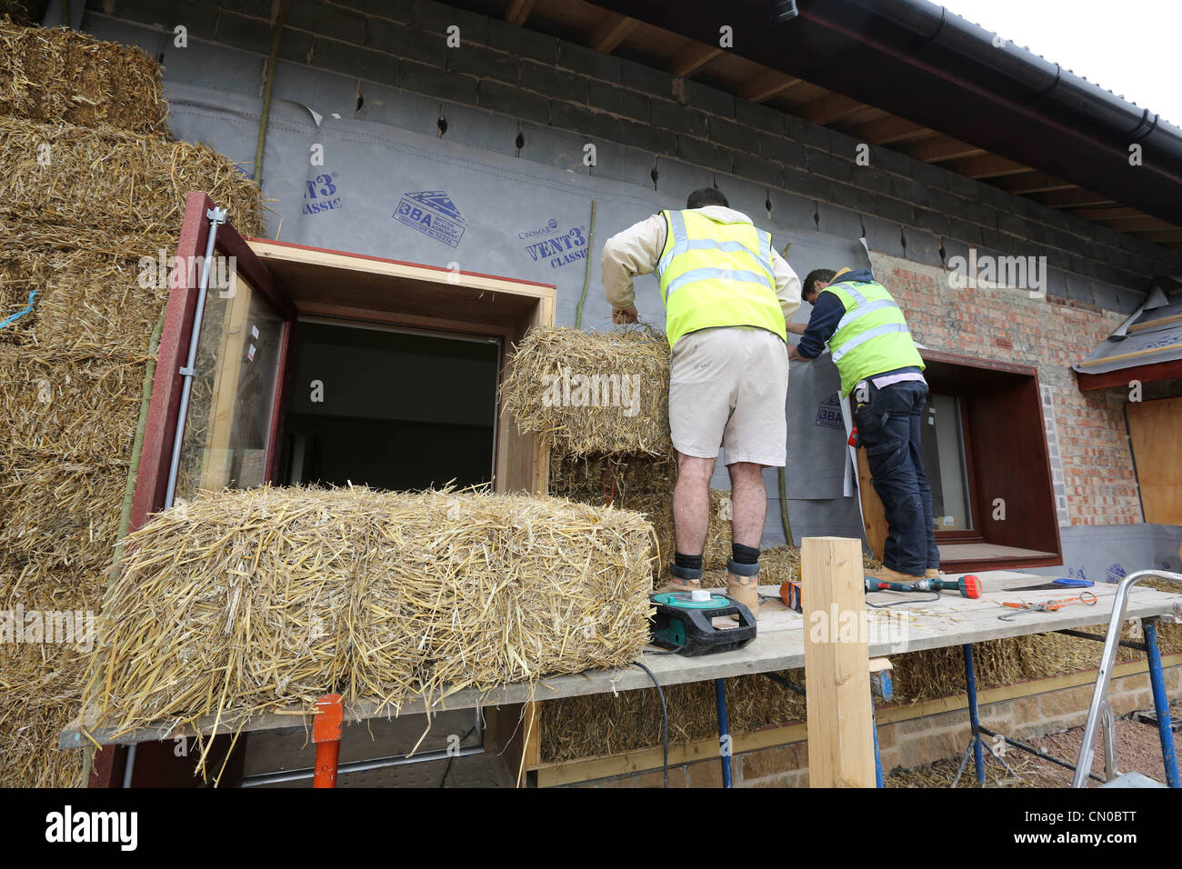 Builders using straw for insulation on a new Ecofriendly building