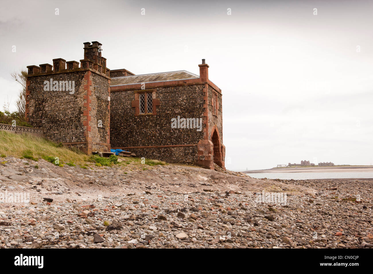 UK, Cumbria, Barrow in Furness, Roa Island, Customs and Excise House on shore with Piel Island in distance Stock Photo