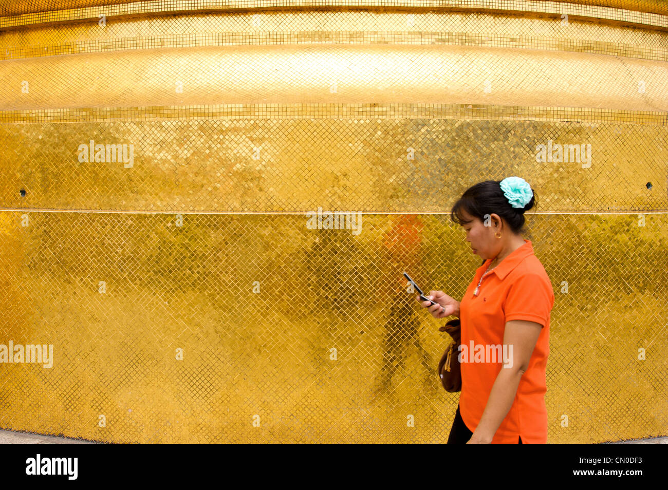 Thai woman walkin,golden pagoda, wat pra keaw,Grand Palace, Bangkok,Thailand Stock Photo