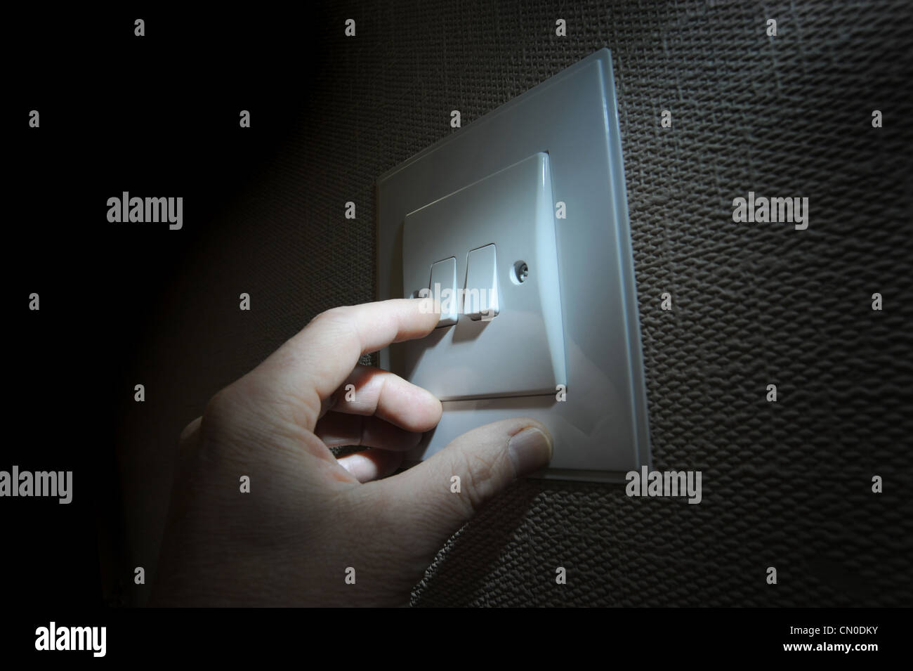 MANS HAND FINGER WITH DOMESTIC LIGHT SWITCH RE ELECTRICITY BILLS FUEL