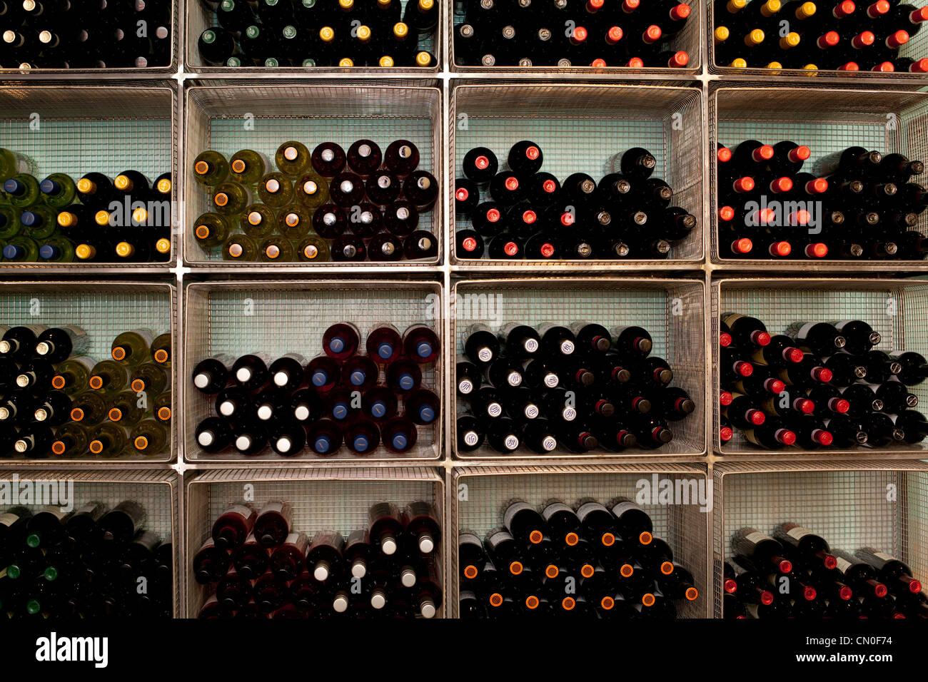Bottles of wine on a rack in a restaurant/cafe, await drinking and ...