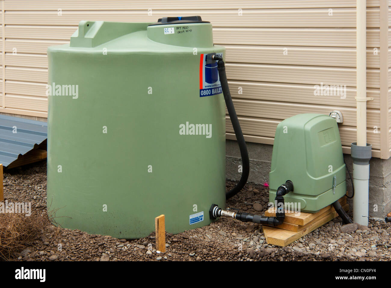 Polyethylene external water tank and pump on rural property in Canterbury, New Zealand. Stock Photo