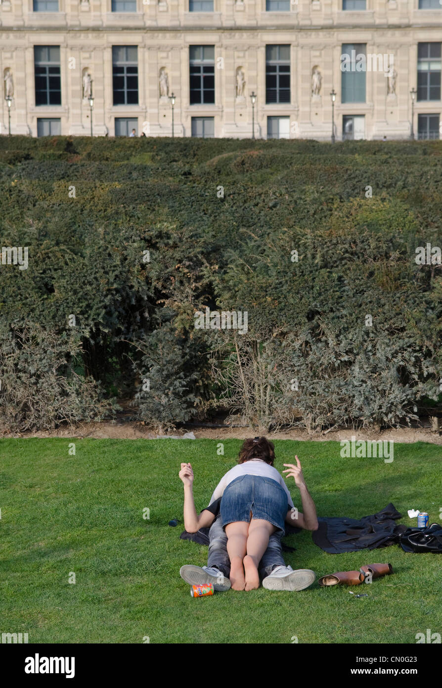 A young couple lying on the grass of the Tuilleries gardens in Paris. Spring. Stock Photo