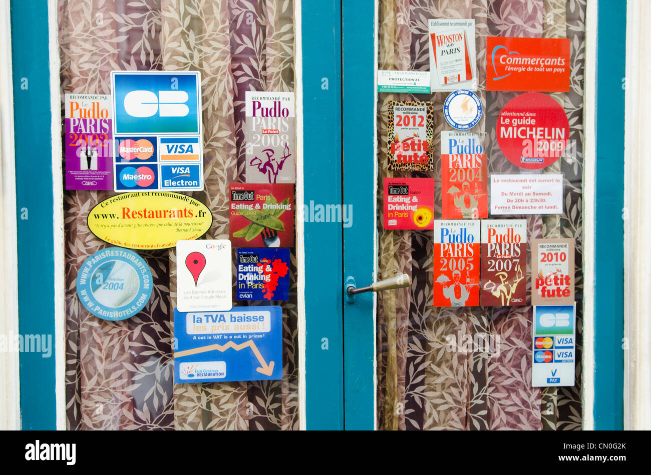 Restaurant doors in Montparnasse area of Paris, with guides and awards stickers. Stock Photo