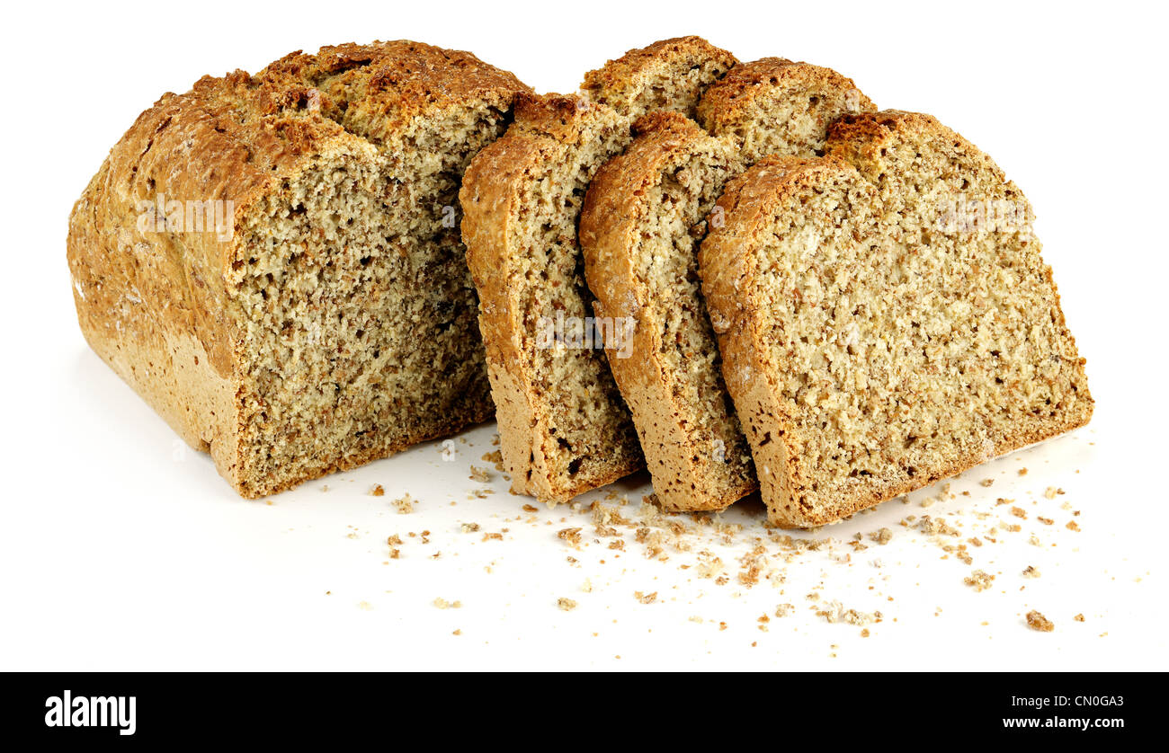 a loaf of bread with three slices and bread crumbs on a white table ...