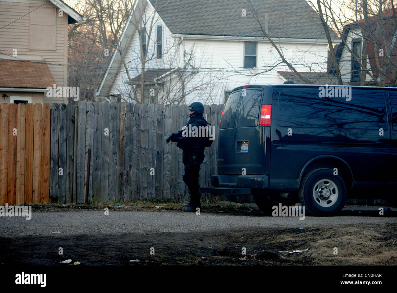 Swat officer,secures back entrance,during a drug raid,fully equipped with weapons. Stock Photo