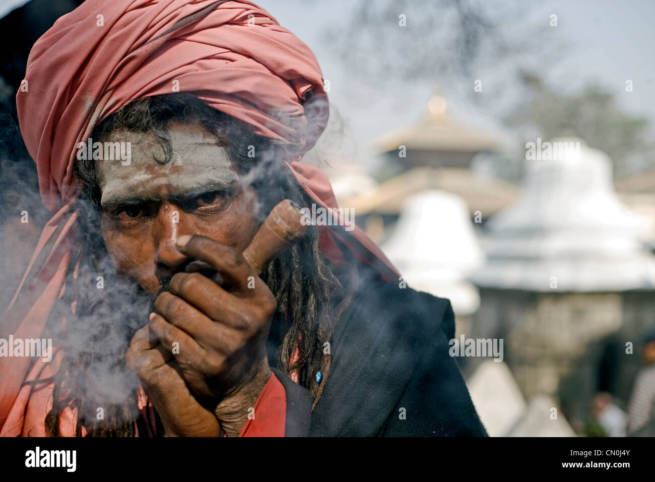Sadhu smoking chilum (clay pipe ) during Shivaratri festival at Pashupatinath , Kathmandu , Nepal Stock Photo