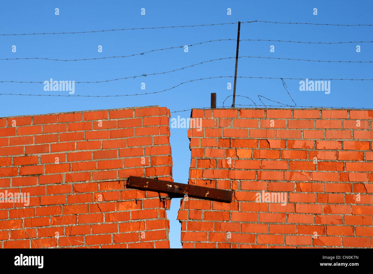 Red Brick broken Wall with barbed wire against blue sky Stock Photo - Alamy