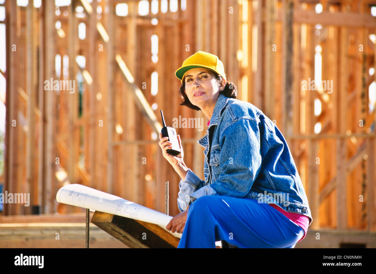 Hispanic Woman heads up construction site using her walkie talkie and