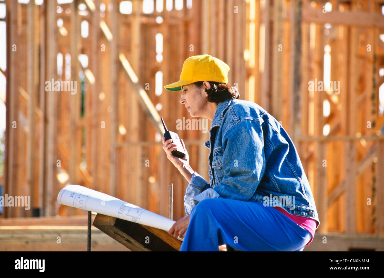 Hispanic Woman heads up construction site using her walkie talkie and