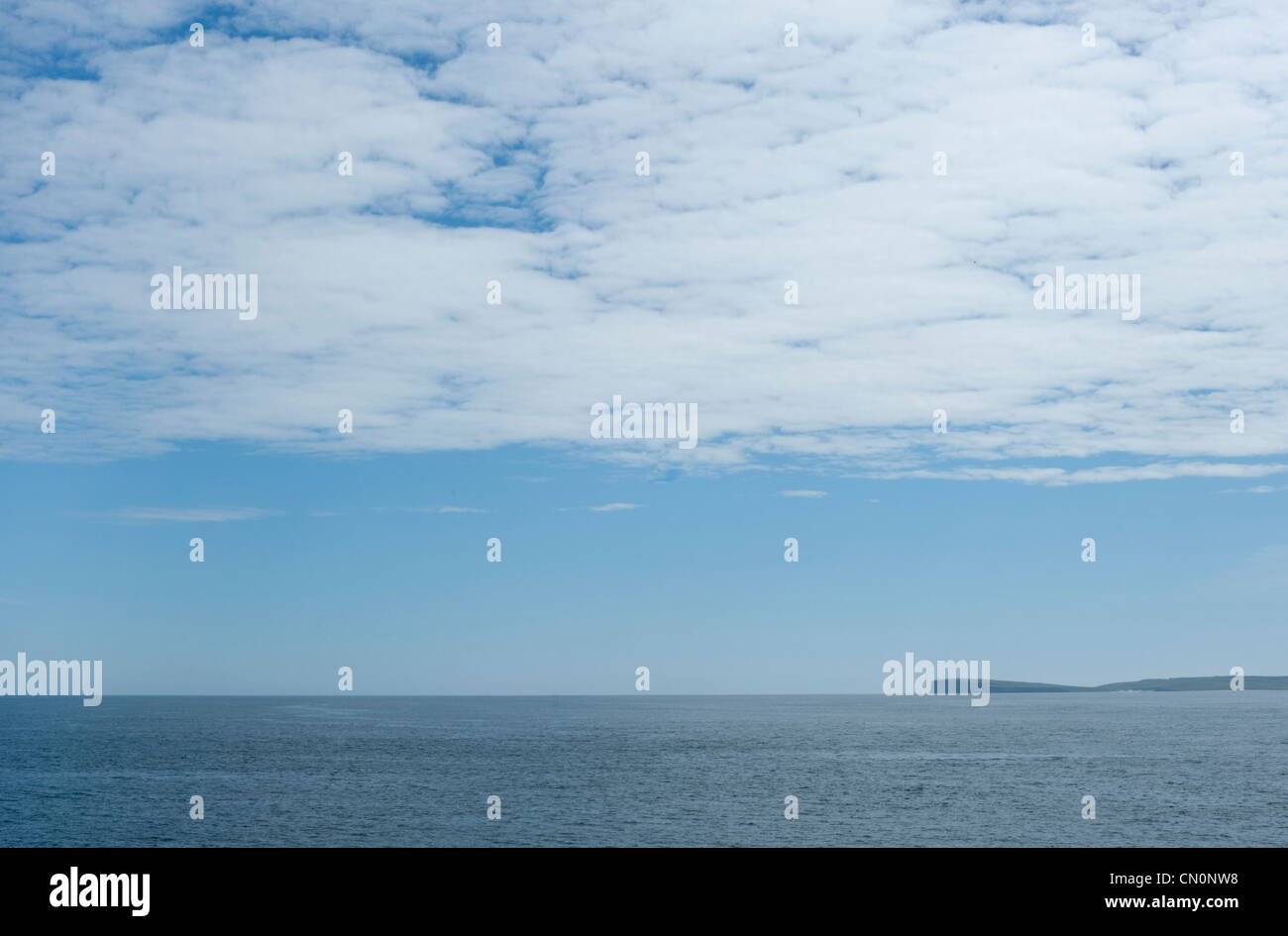 A view of the Orkney Islands from a ferry travelling across the Pentland Firth on a clear blue sunny day in Scotland Stock Photo
