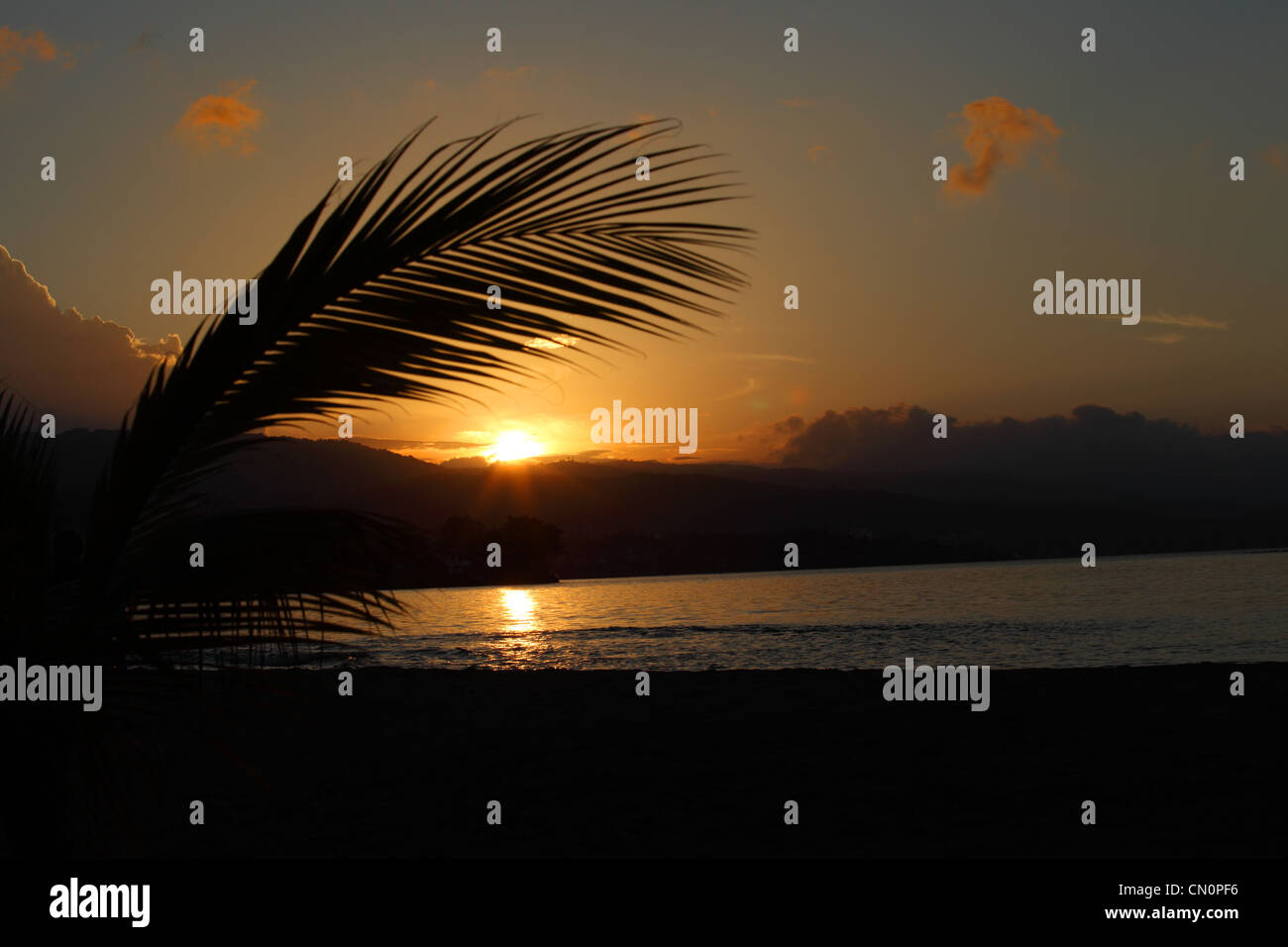 The Sun setting over a bay at Sans Souci, Jamaica Stock Photo