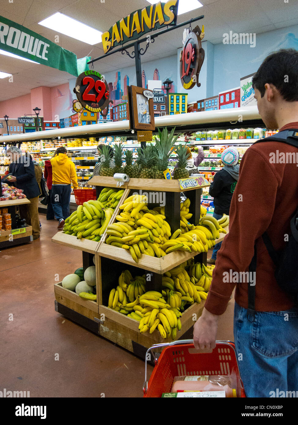 young man looking at banana and fruit stand in Trader Joe's, 22 St., Philadelphia, USA Stock Photo