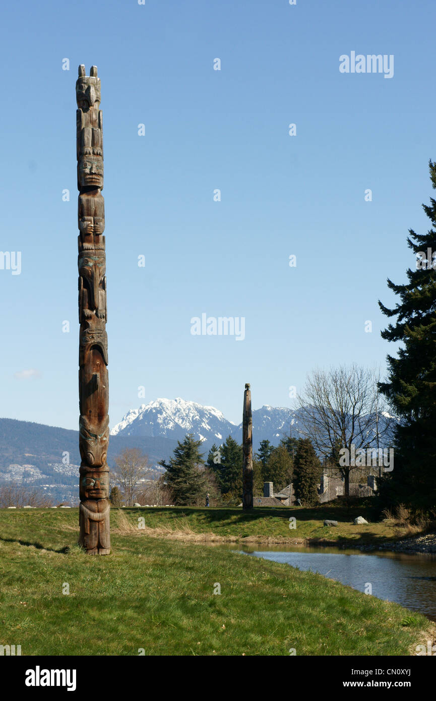 West Coast First Nations totem poles with mountains in background, Museum of Anthropology, University of British Columbia, Vancouver, Canada. Stock Photo