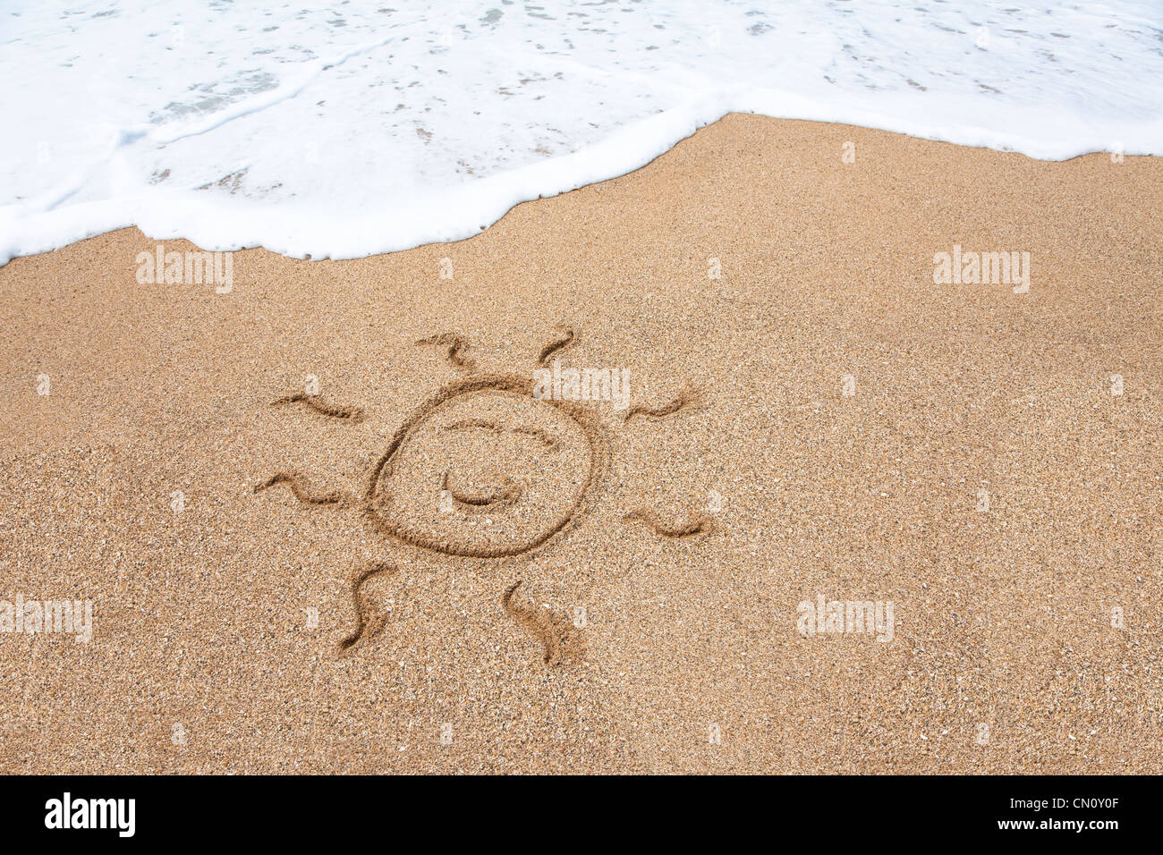 smiling sun face on the beach Stock Photo