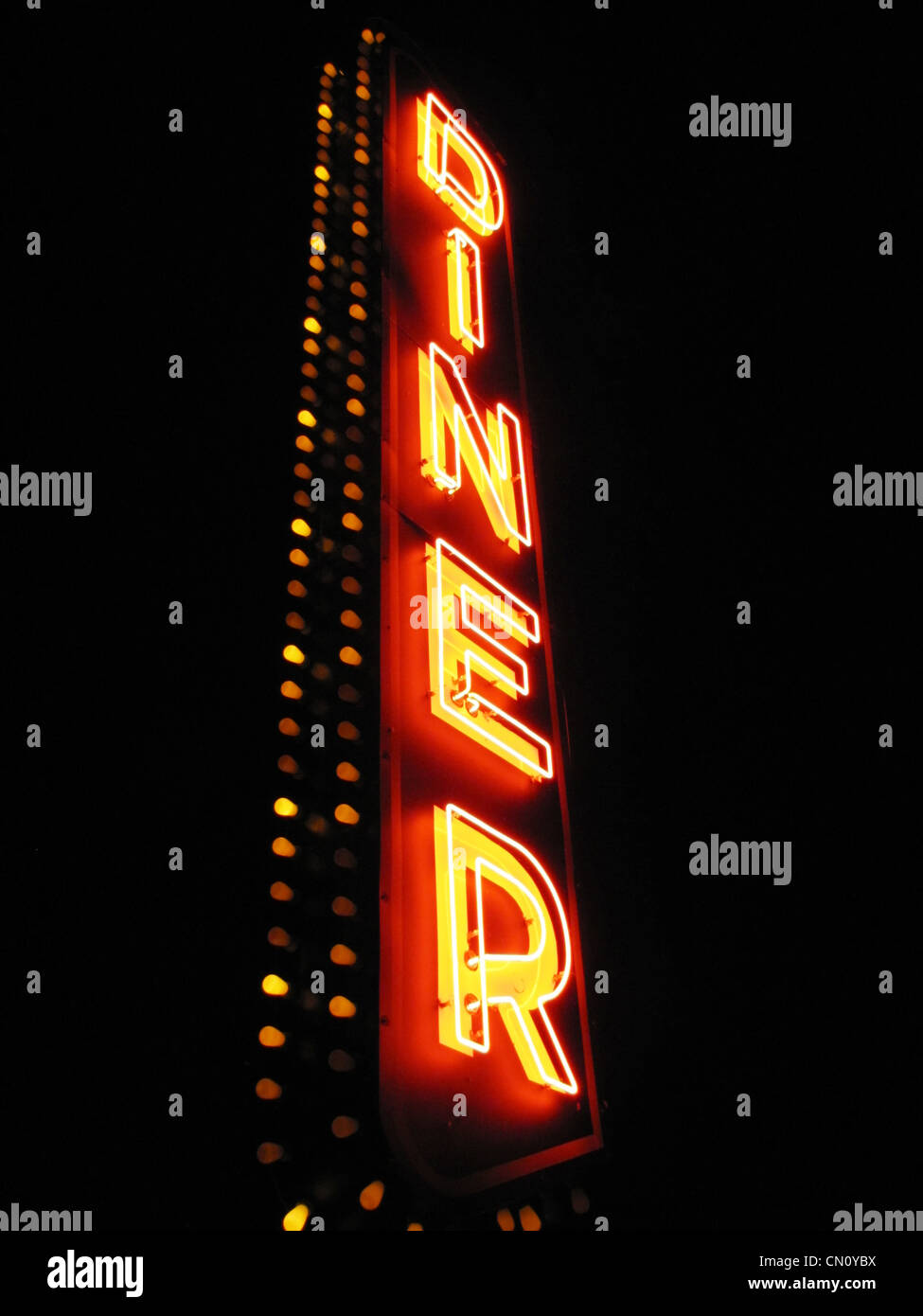 A large neon sign says 'DINER' against a black night sky. Stock Photo