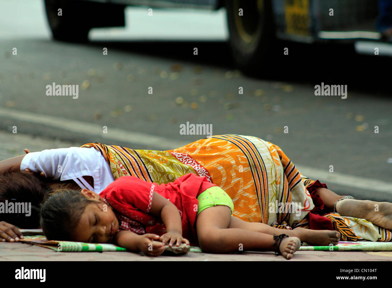 homeless mother and child sleeping on the footpath in Mumbai, India Stock Photo
