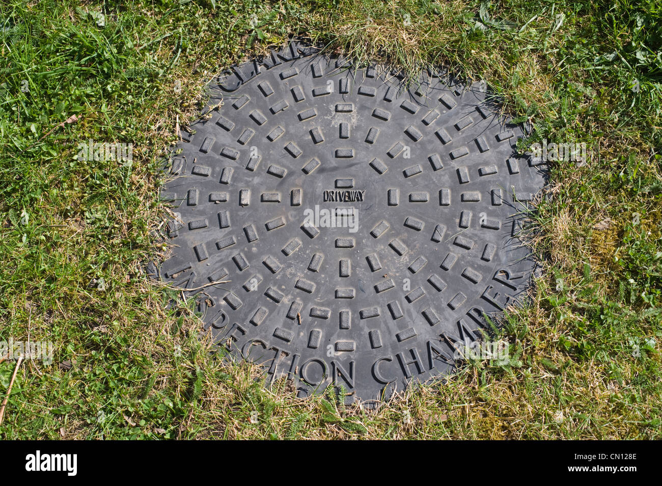 Driveway inspection chamber on grass lawn Stock Photo