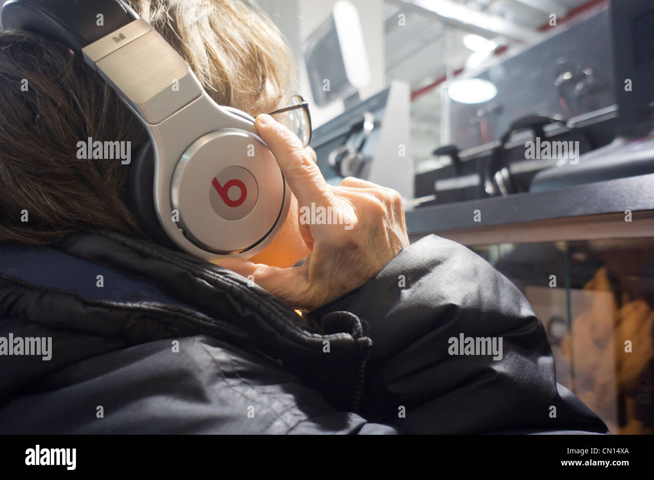 A customer in a Best Buy store in New York listens on Beats by Dr. Dre headphones Stock Photo