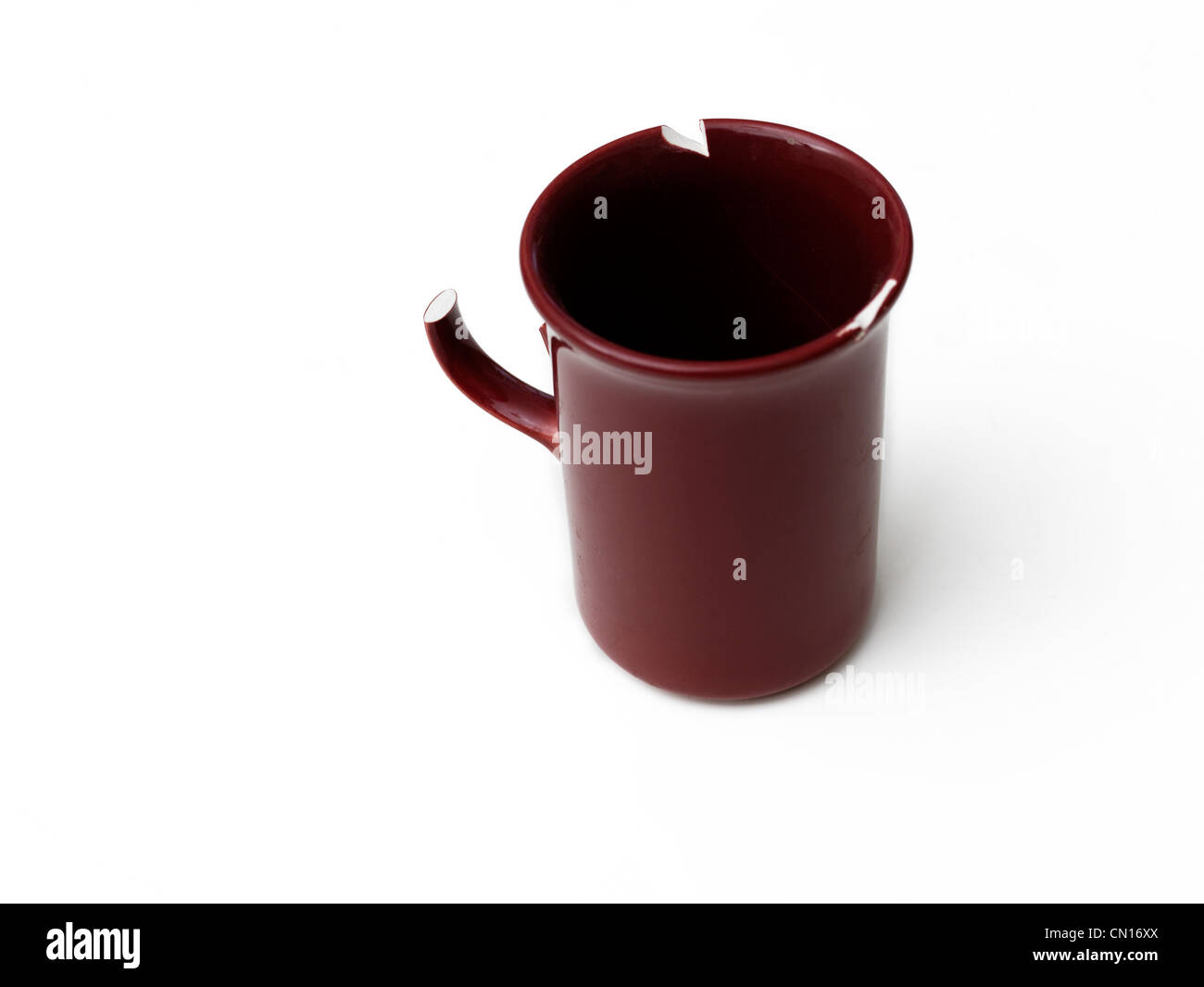 Red Mug Chipped On The Rim and Broken Handle Stock Photo