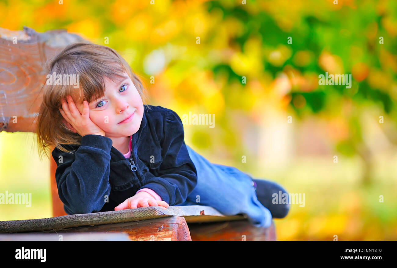 little girl sitting on the bench in park Stock Photo - Alamy
