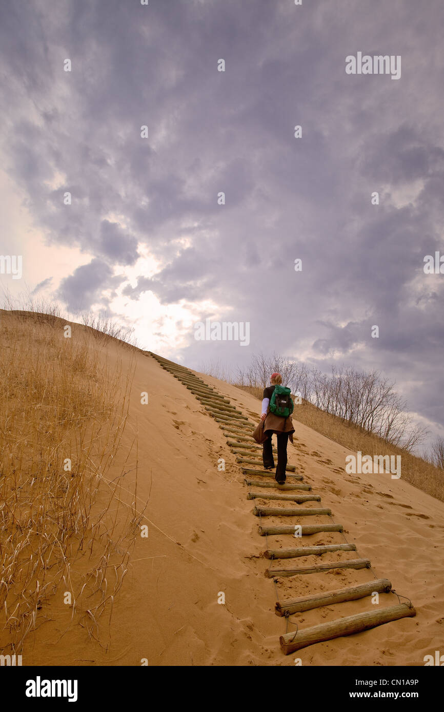 Woman hiking up a sand dune, The Spirit Sands, Spruce Woods Provincial Park, Manitoba Stock Photo